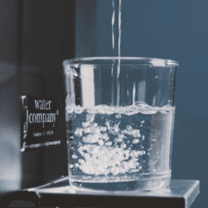 Glas som fylls på med kolsyrat vatten från Water Companys London vattenautomat.