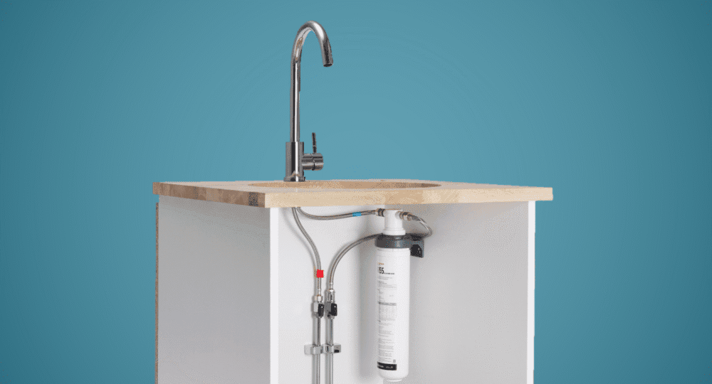 En kökskran med ett vattenfilter installerat under vasken.