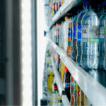 Hyllor med plastflaskor med olika typer av dryck