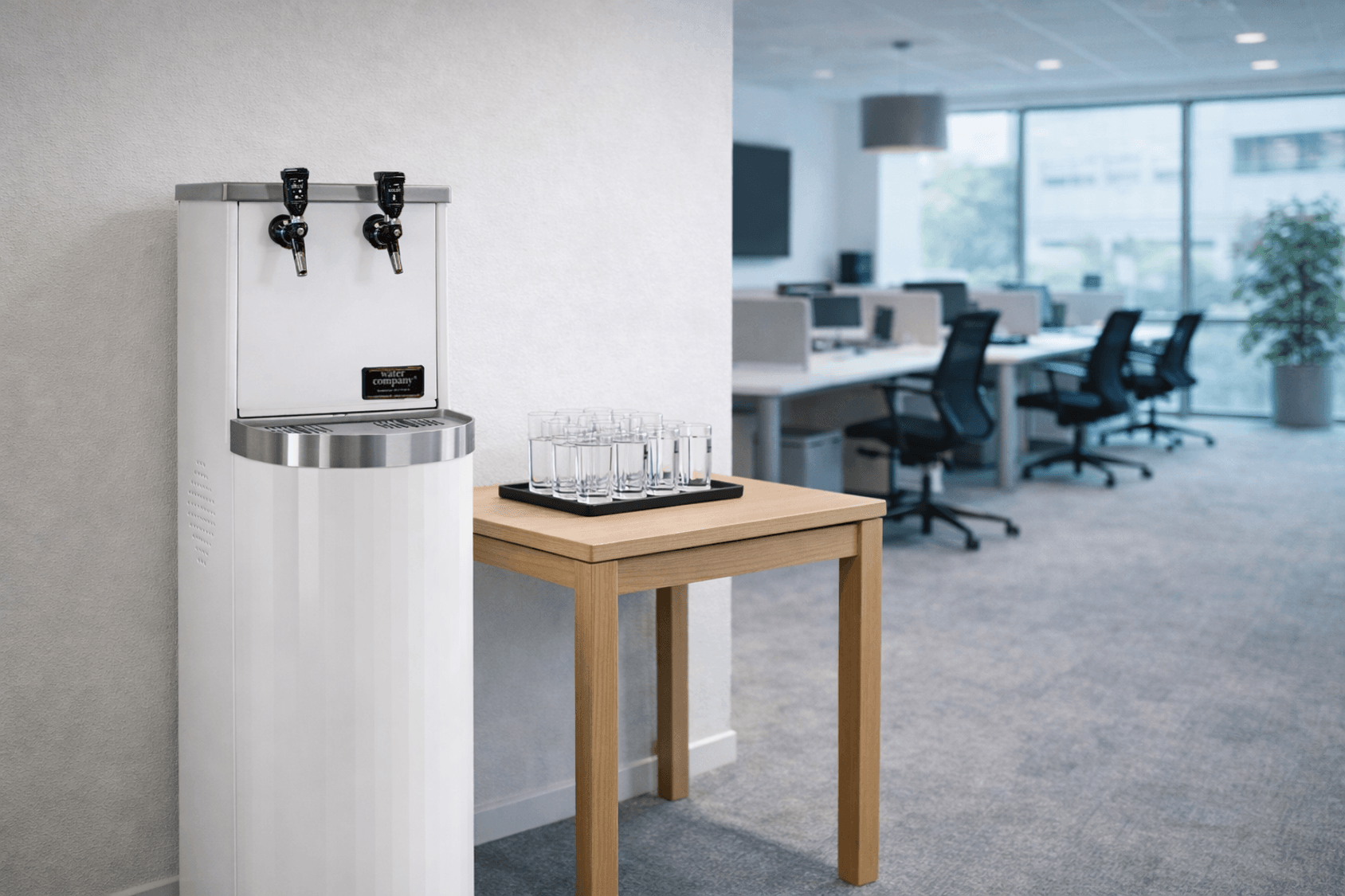Bild på en fristående vattenautomat (Tower) med två tappkranar i ett kontor.