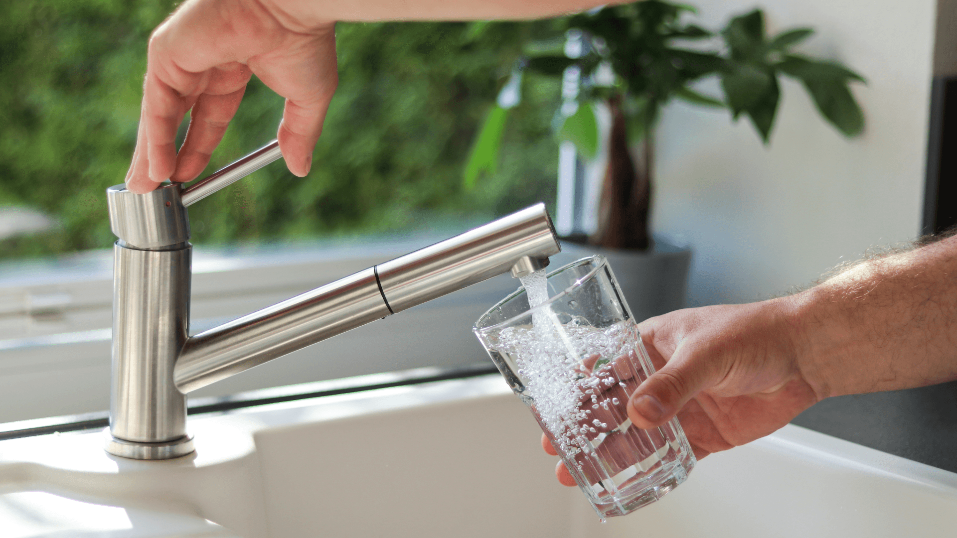 Dricksvatten i ett glas från en kran